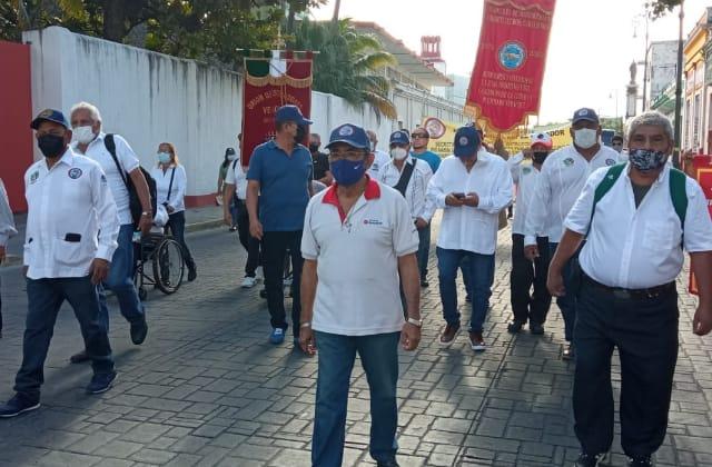 Hasta en silla de ruedas, marchan extrabajadores portuarios en Veracruz 